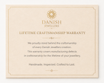 Danish Jewellers lifetime craftsmanship warranty card on a white background