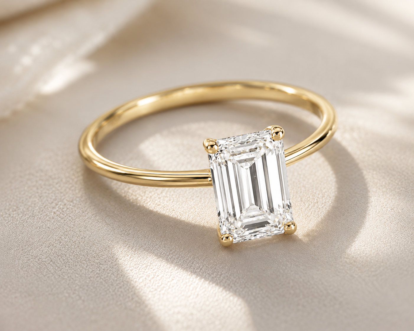 Gold ring with a rectangular diamond on a beige fabric background