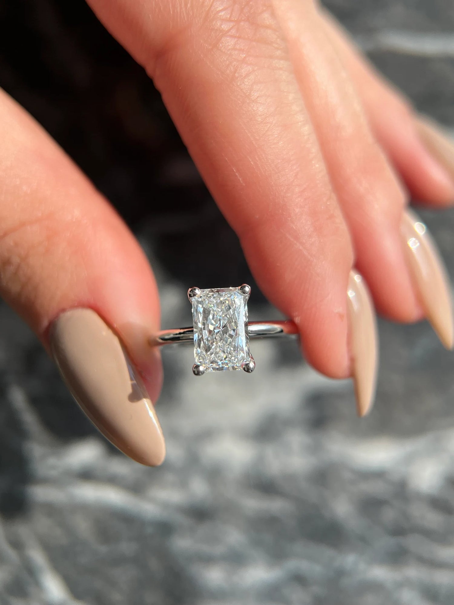 Diamond ring on a finger with a blurred background